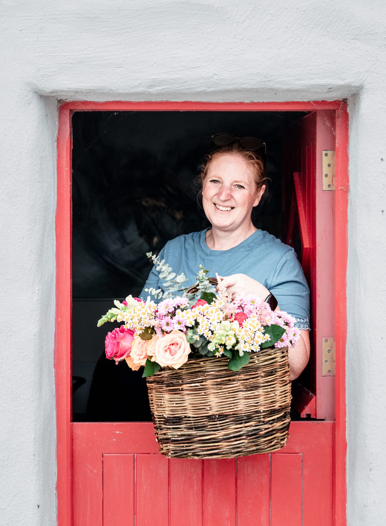 Lynda with a Basket of fresh cut flowers standing in a red half door