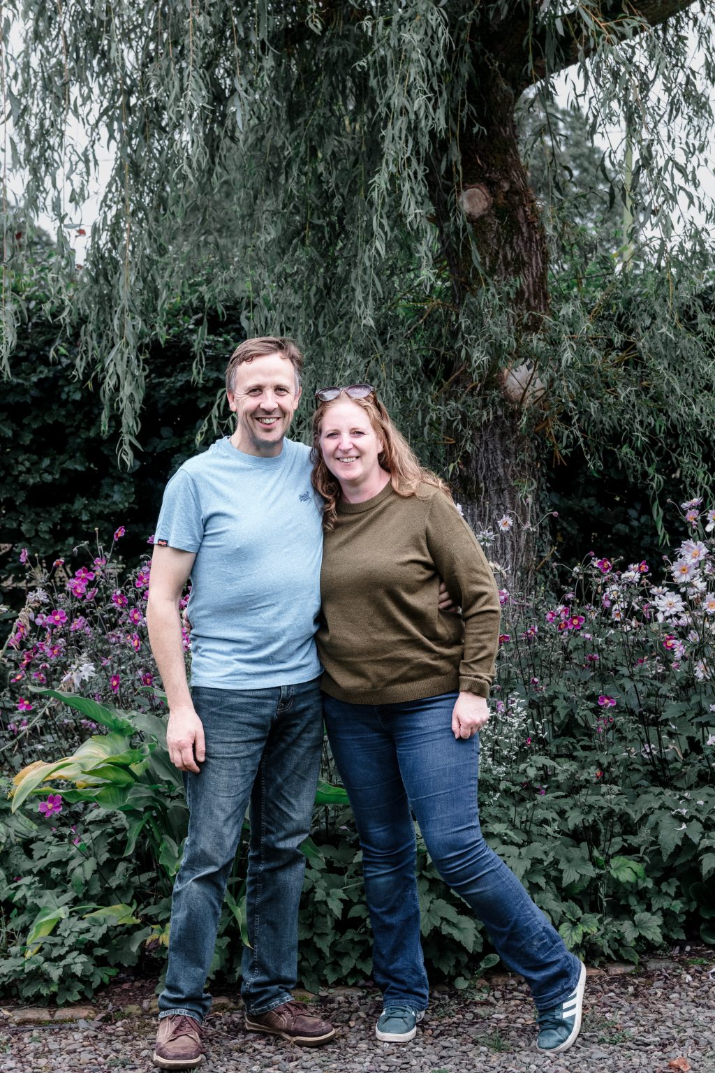 Lynda and Bryan in front of trees and plants