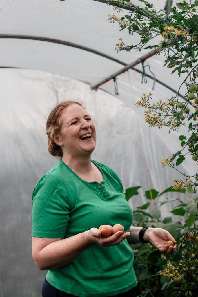 Lynda smiling holding harvested produce